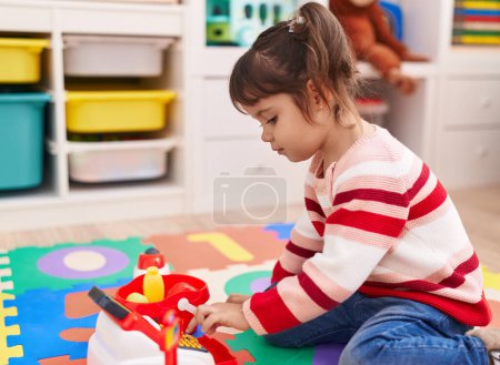 Photo for Adorable hispanic girl playing supermarket game sitting on floor at kindergarten - Royalty Free Image