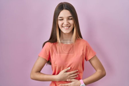 Photo for Teenager girl standing over pink background smiling and laughing hard out loud because funny crazy joke with hands on body. - Royalty Free Image