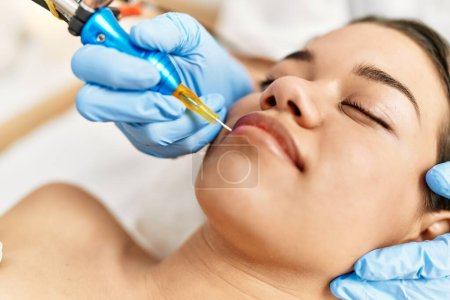 Photo for Young latin woman relaxed having microblading lips treatment at beauty center - Royalty Free Image