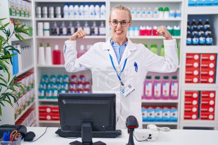 Photo for Young caucasian woman working at pharmacy drugstore showing arms muscles smiling proud. fitness concept. - Royalty Free Image