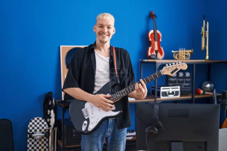 Téléchargez les photos : Jeune homme caucasien musicien jouant de la guitare électrique au studio de musique - en image libre de droit
