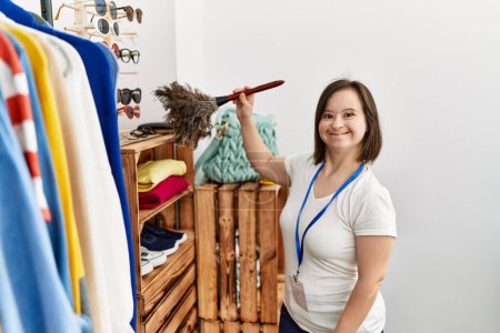 Téléchargez les photos : Femme brune avec syndrome du duvet travaillant comme employé de magasin nettoyant la poussière au magasin de détail - en image libre de droit