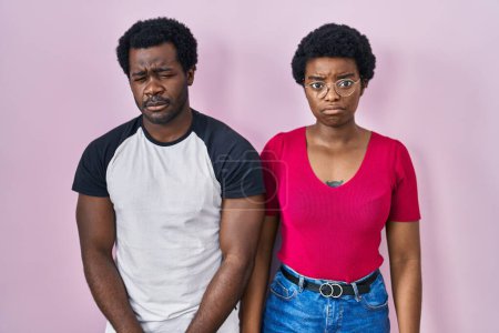 Foto de Joven pareja afroamericana de pie sobre fondo rosa deprimido y preocupación por la angustia, llorando enojado y asustado. expresión triste. - Imagen libre de derechos