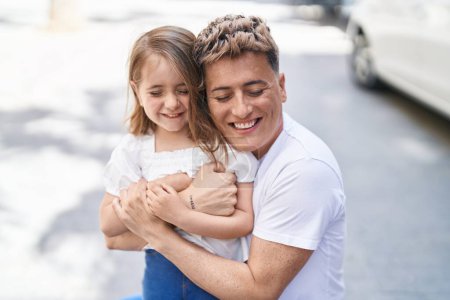 Téléchargez les photos : Père et fille souriant confiants se serrant dans leurs bras au parc - en image libre de droit