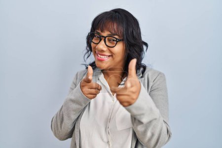 Photo for Hispanic woman standing over isolated background pointing fingers to camera with happy and funny face. good energy and vibes. - Royalty Free Image