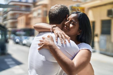 Téléchargez les photos : Man and woman interracial couple hugging each other at street - en image libre de droit