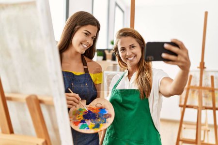 Photo for Mother and daughter smiling confident make selfie by the smartphone at art studio - Royalty Free Image