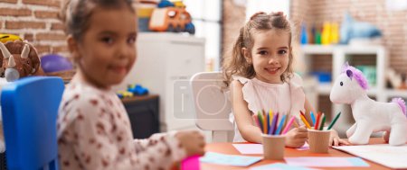 Photo for Two kids preschool students sitting on table drawing on paper at kindergarten - Royalty Free Image