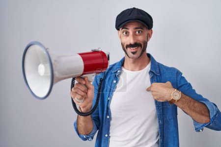 Photo for Hispanic man with beard shouting through megaphone pointing finger to one self smiling happy and proud - Royalty Free Image