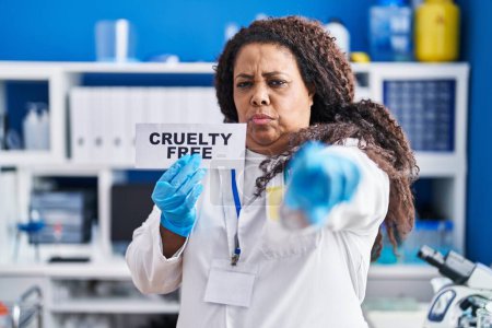 Photo for Plus size hispanic woman working on cruelty free laboratory pointing with finger to the camera and to you, confident gesture looking serious - Royalty Free Image