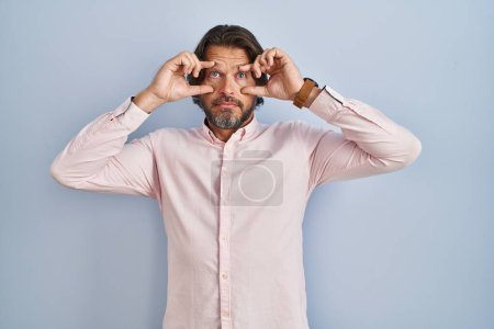 Téléchargez les photos : Handsome middle age man wearing elegant shirt background trying to open eyes with fingers, sleepy and tired for morning fatigue - en image libre de droit