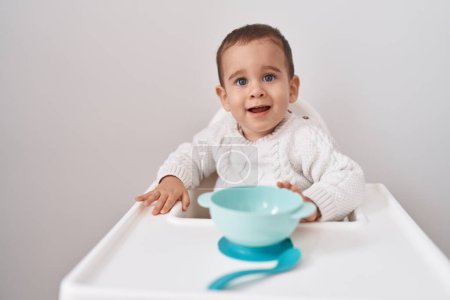 Photo for Adorable hispanic toddler smiling confident sitting on highchair over isolated white background - Royalty Free Image