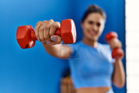 Photo for Young latin woman wearing sportswear boxing using dumbbells at sport center - Royalty Free Image