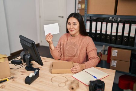Téléchargez les photos : Jeune femme hispanique commerce électronique ouvrier d'entreprise tenant enveloppe lettre au bureau - en image libre de droit