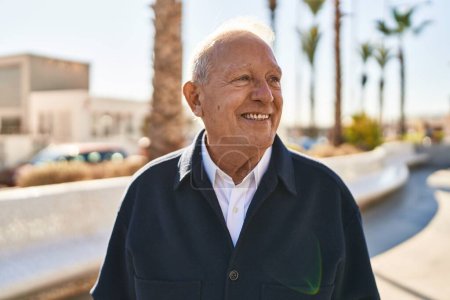 Foto de Hombre mayor sonriendo confiado de pie en la calle - Imagen libre de derechos