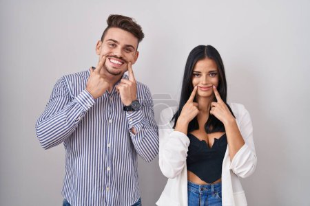 Téléchargez les photos : Jeune couple hispanique debout sur fond blanc souriant avec la bouche ouverte, les doigts pointant et forçant sourire joyeux - en image libre de droit