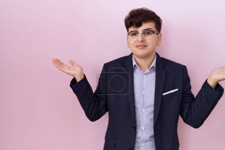 Photo for Young non binary man with beard wearing suit and tie clueless and confused expression with arms and hands raised. doubt concept. - Royalty Free Image