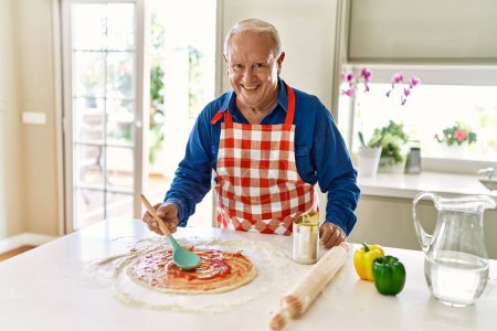 Photo for Senior man smiling confident cooking pizza at kitchen - Royalty Free Image