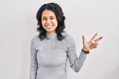 Photo for Hispanic woman with dark hair standing over isolated background showing and pointing up with fingers number three while smiling confident and happy. - Royalty Free Image