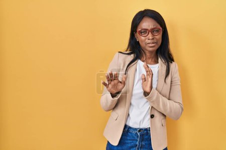 Photo for African young woman wearing glasses disgusted expression, displeased and fearful doing disgust face because aversion reaction. with hands raised - Royalty Free Image