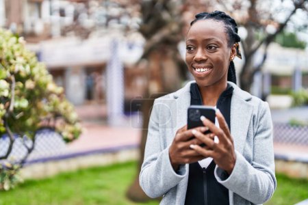 Photo for African american woman smiling confident using smartphone at park - Royalty Free Image