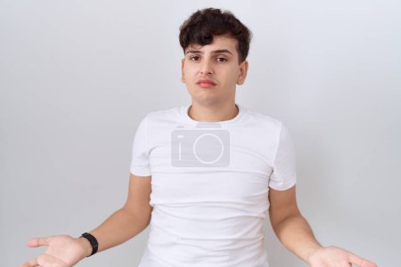 Photo for Young non binary man wearing casual white t shirt clueless and confused with open arms, no idea concept. - Royalty Free Image