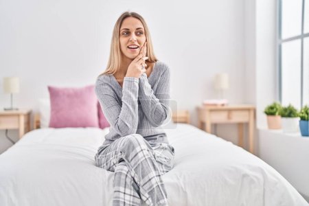 Photo for Young woman smiling confident sitting on bed at bedroom - Royalty Free Image
