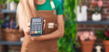 Photo for Young blonde woman florist holding data phone at flower shop - Royalty Free Image