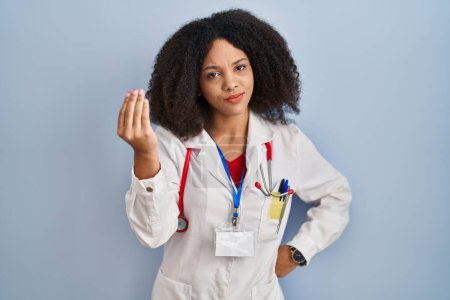 Foto de Joven mujer afroamericana vistiendo uniforme médico y estetoscopio haciendo gesto italiano con la mano y los dedos expresión confiada - Imagen libre de derechos