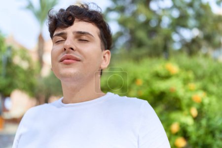 Photo for Non binary man breathing with closed eyes at park - Royalty Free Image
