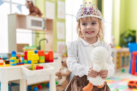 Photo for Adorable blonde girl wearing princess crown holding duck toy at kindergarten - Royalty Free Image