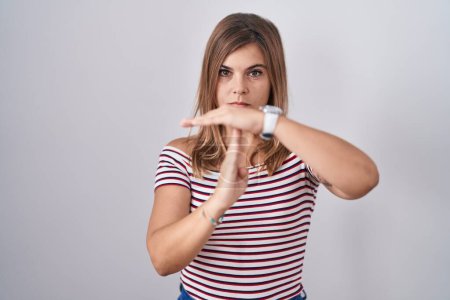 Photo for Young hispanic woman standing over isolated background doing time out gesture with hands, frustrated and serious face - Royalty Free Image