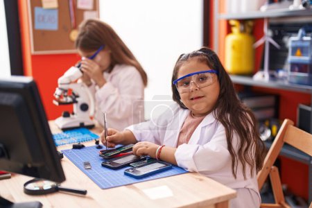 Photo for Two kids students using microscope repairing smartphone at laboratory classroom - Royalty Free Image