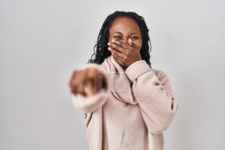 Photo for African woman standing over white background laughing at you, pointing finger to the camera with hand over mouth, shame expression - Royalty Free Image