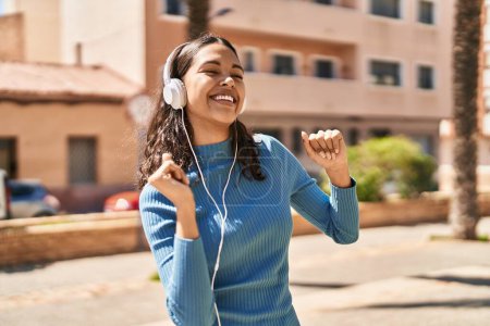 Téléchargez les photos : Young african american woman listening to music and dancing at park - en image libre de droit