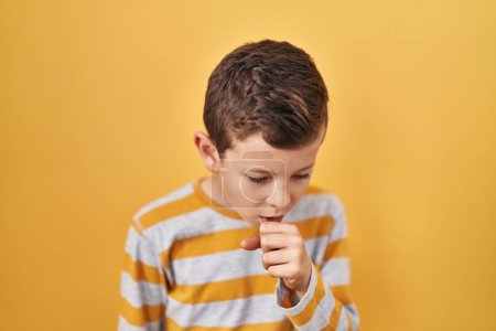 Photo for Young caucasian kid standing over yellow background feeling unwell and coughing as symptom for cold or bronchitis. health care concept. - Royalty Free Image