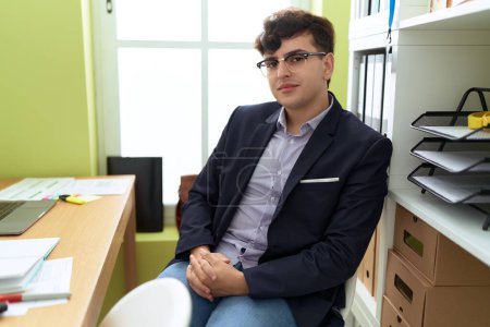 Téléchargez les photos : Non binary man business worker smiling confident sitting on table at office - en image libre de droit