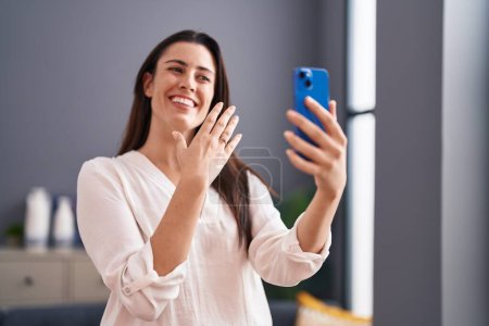 Photo for Young beautiful hispanic woman having video call showing engagement ring at home - Royalty Free Image