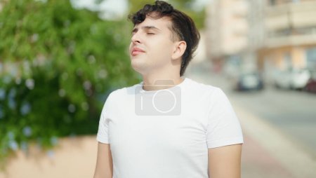 Téléchargez les photos : Non binary man breathing with closed eyes at park - en image libre de droit