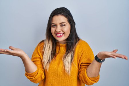 Téléchargez les photos : Young hispanic woman standing over isolated background smiling cheerful offering hands giving assistance and acceptance. - en image libre de droit