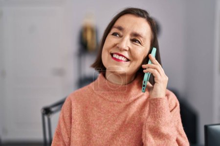 Téléchargez les photos : Middle age woman musician smiling confident talking on the smartphone at music studio - en image libre de droit