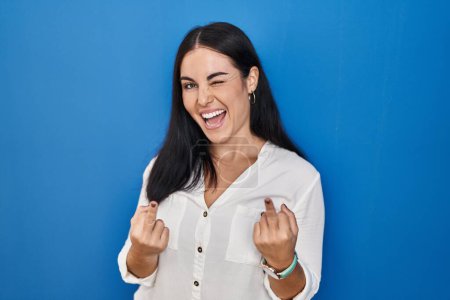 Téléchargez les photos : Young hispanic woman standing over blue background showing middle finger doing fuck you bad expression, provocation and rude attitude. screaming excited - en image libre de droit