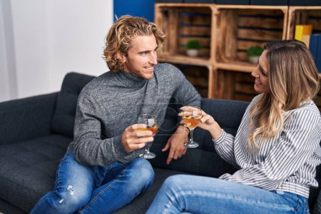 Téléchargez les photos : Homme et femme couple souriant toasts confiants avec verre de champagne à la maison - en image libre de droit