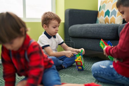 Foto de Grupo de niños jugando con juguetes sentados en el suelo en casa - Imagen libre de derechos