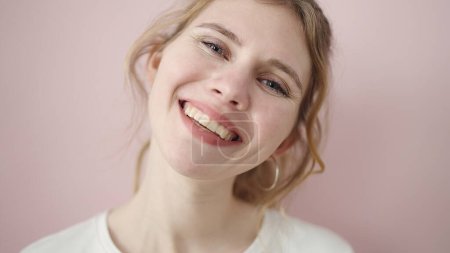 Foto de Young blonde woman smiling confident standing over isolated pink background - Imagen libre de derechos
