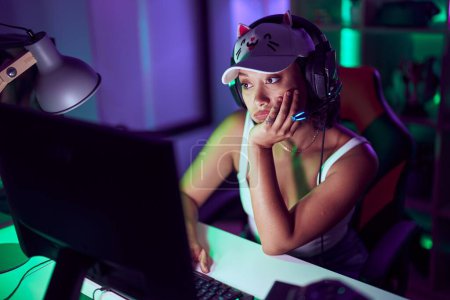 Téléchargez les photos : Jeune belle hispanique femme streamer souligné en utilisant l'ordinateur à la salle de jeux - en image libre de droit