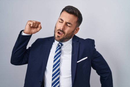 Photo for Handsome hispanic man wearing suit and tie stretching back, tired and relaxed, sleepy and yawning for early morning - Royalty Free Image