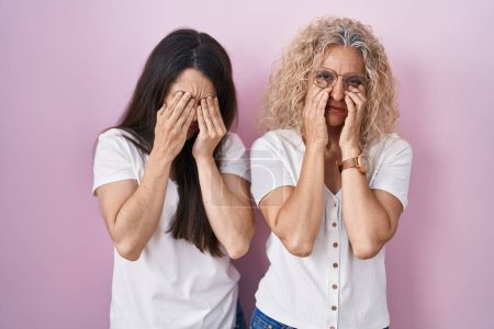 Photo for Mother and daughter standing together over pink background rubbing eyes for fatigue and headache, sleepy and tired expression. vision problem - Royalty Free Image