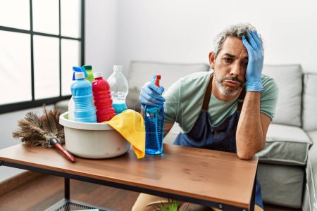 Téléchargez les photos : Moyen âge homme aux cheveux gris fatigué table de nettoyage à la maison - en image libre de droit