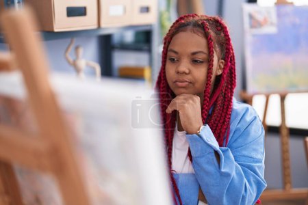 Téléchargez les photos : African american woman artist looking draw with doubt expression at art studio - en image libre de droit